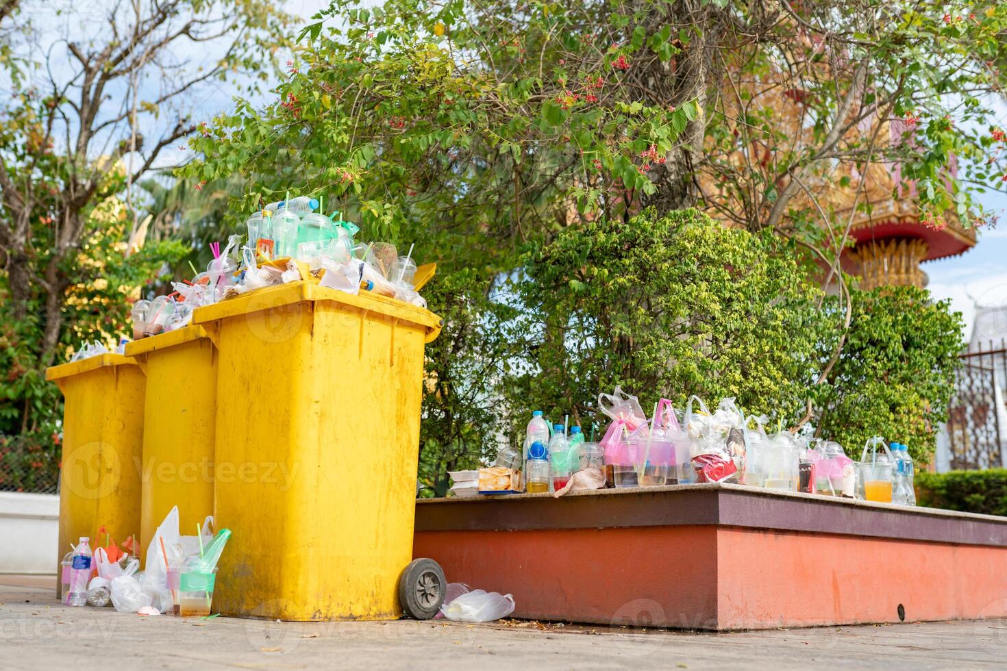 Garbage bins are overflowing since there are not enough receptacles and bins to handle the flow of waste for that area. photo