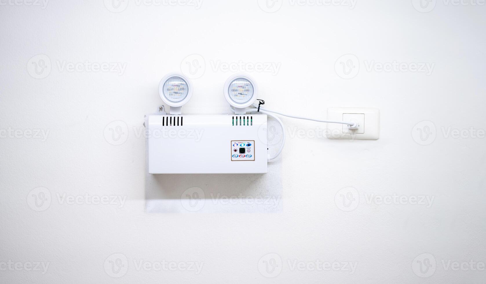 Automatic EMERGENCY LIGHT in hospital is charging and power pluging on the wall that ready to use when the power went out. photo