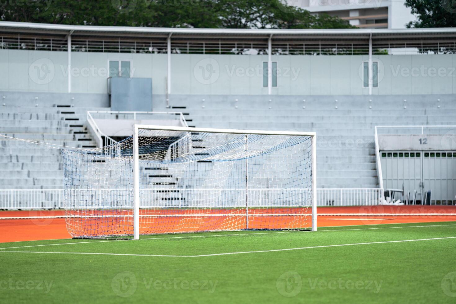Goal area of artificial grass or turf court yard in front of an empty grand stand and entrance - exit main door. photo