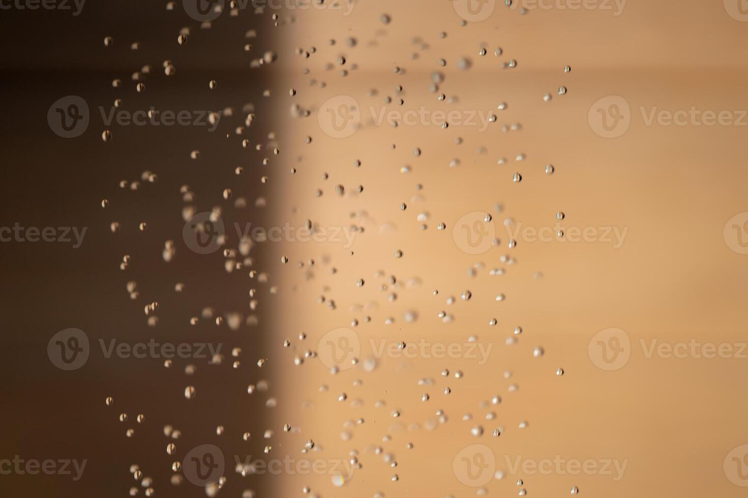 Abstract backgrond dropped water stop motion and dripping to the ground from Shower on blur orange brown background at outdoor light. photo