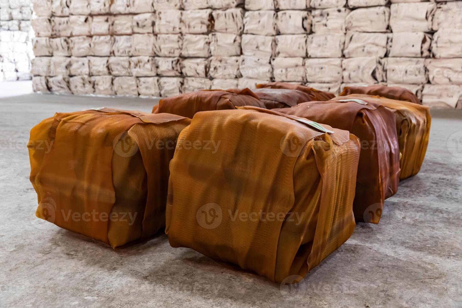 Raw rubber sheet products packed into a cube shape in the warehouse preparing for delivery to customers. Packages were placed on the cement floor. photo