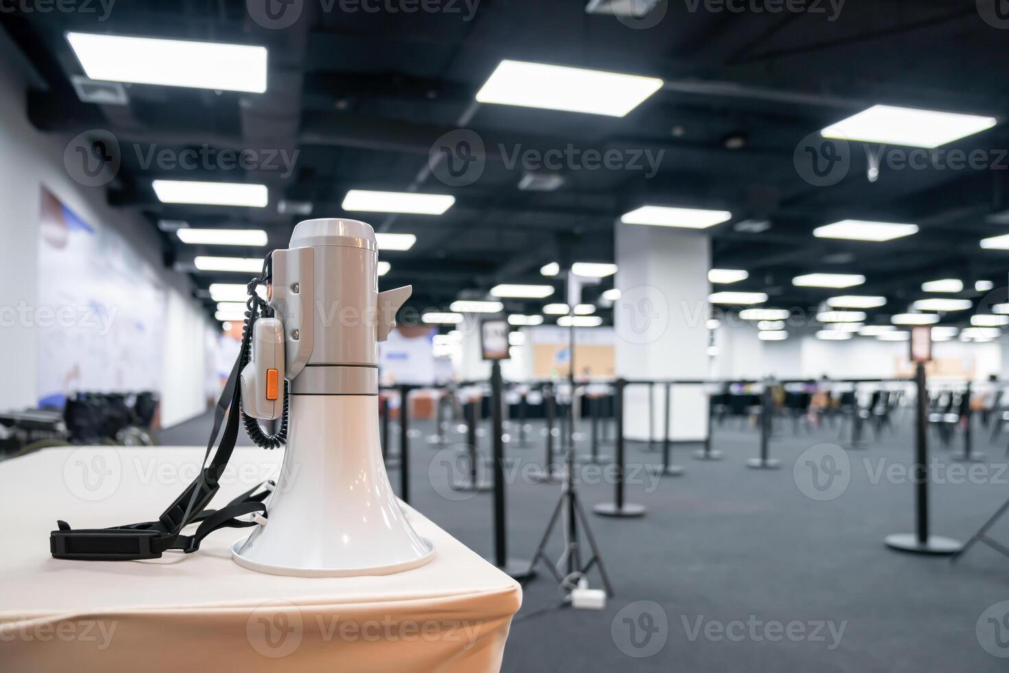 Two white - gray MEGAPHONE are laid on cream table in empty hall, ready to used for event corona virus vaccine booster in Bangkok, Thailand. photo