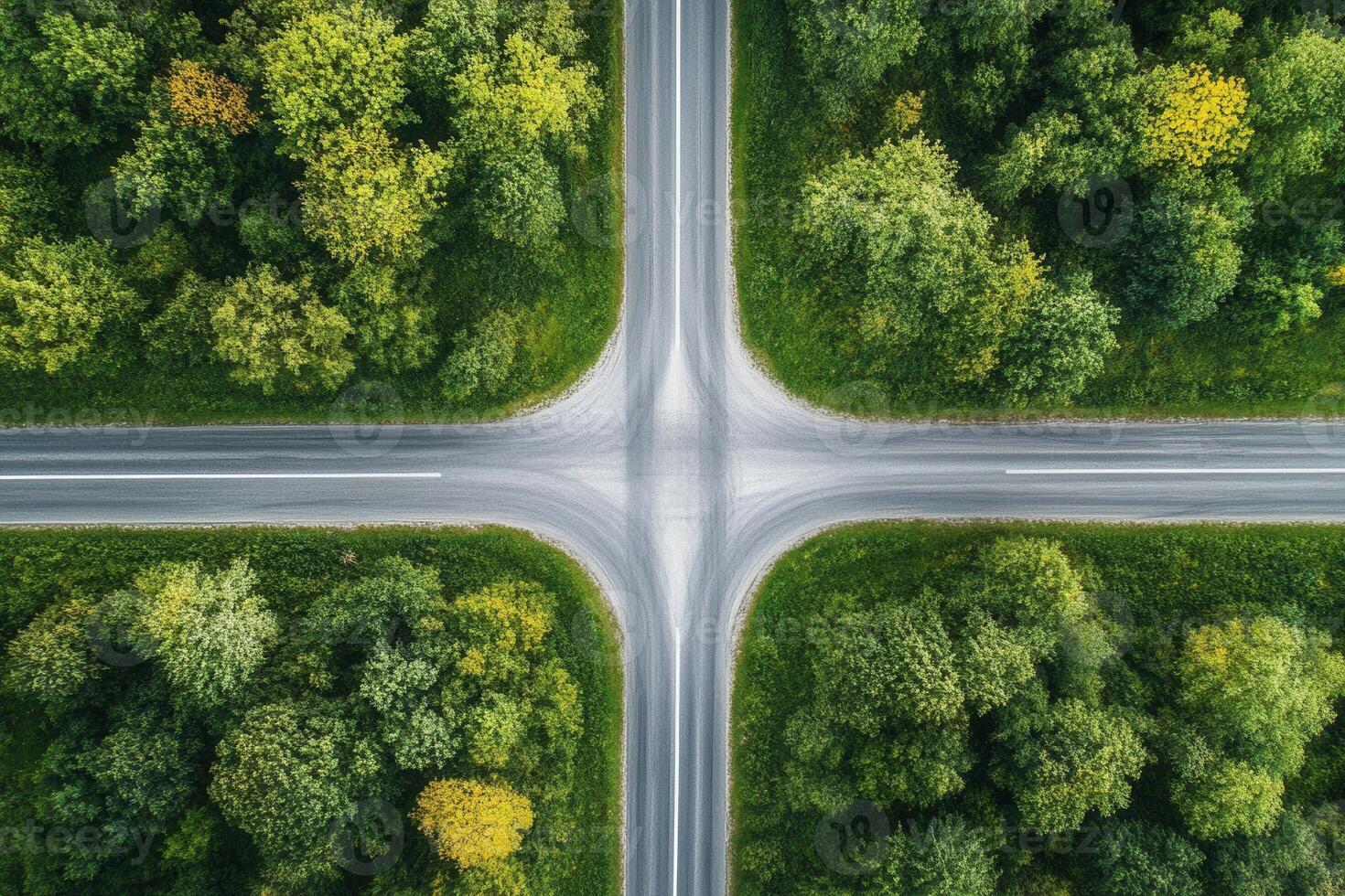 Aerial view of four-way intersection surrounded by lush green forest. photo