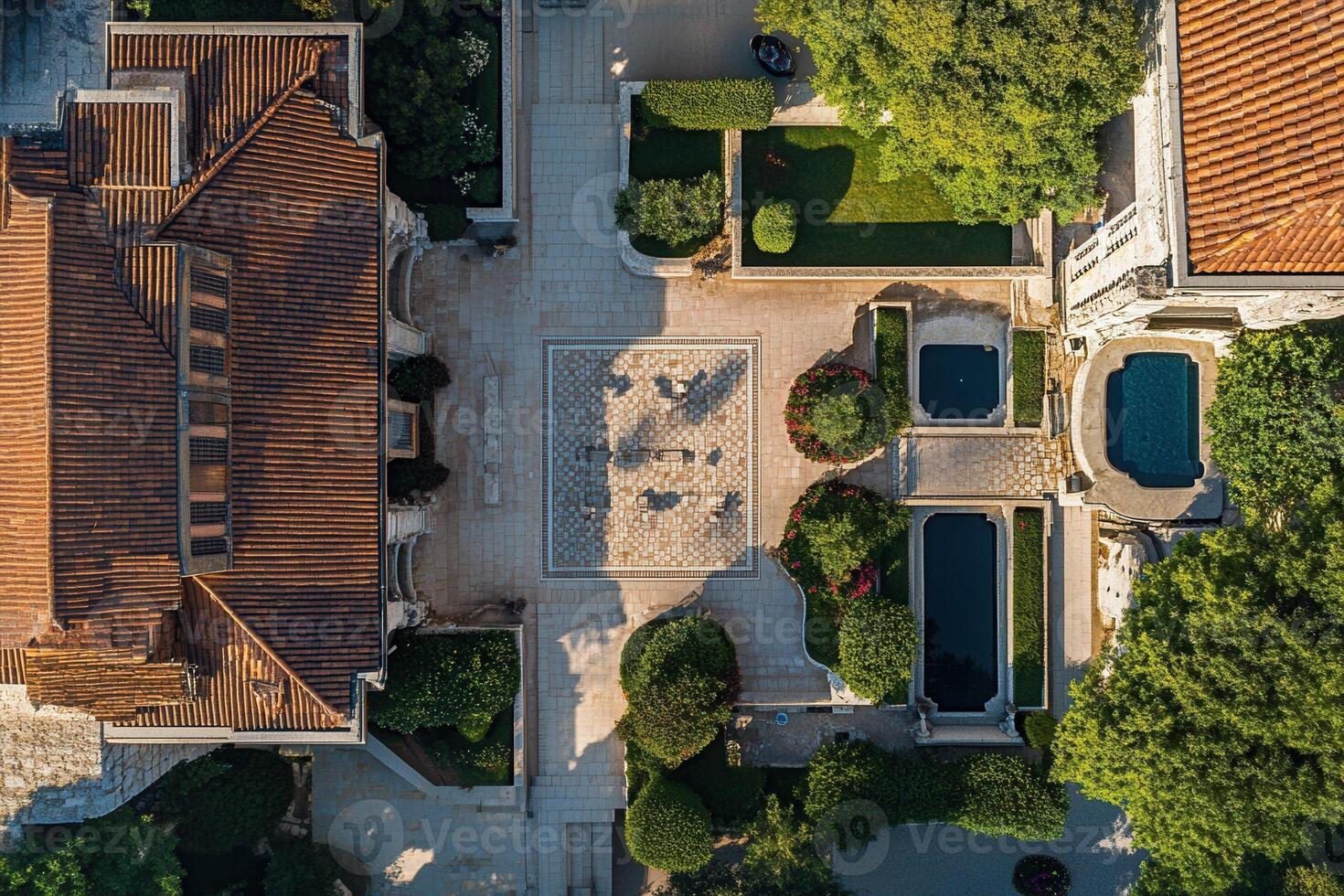 Aerial view of a symmetrical courtyard with buildings, pools, and gardens. photo