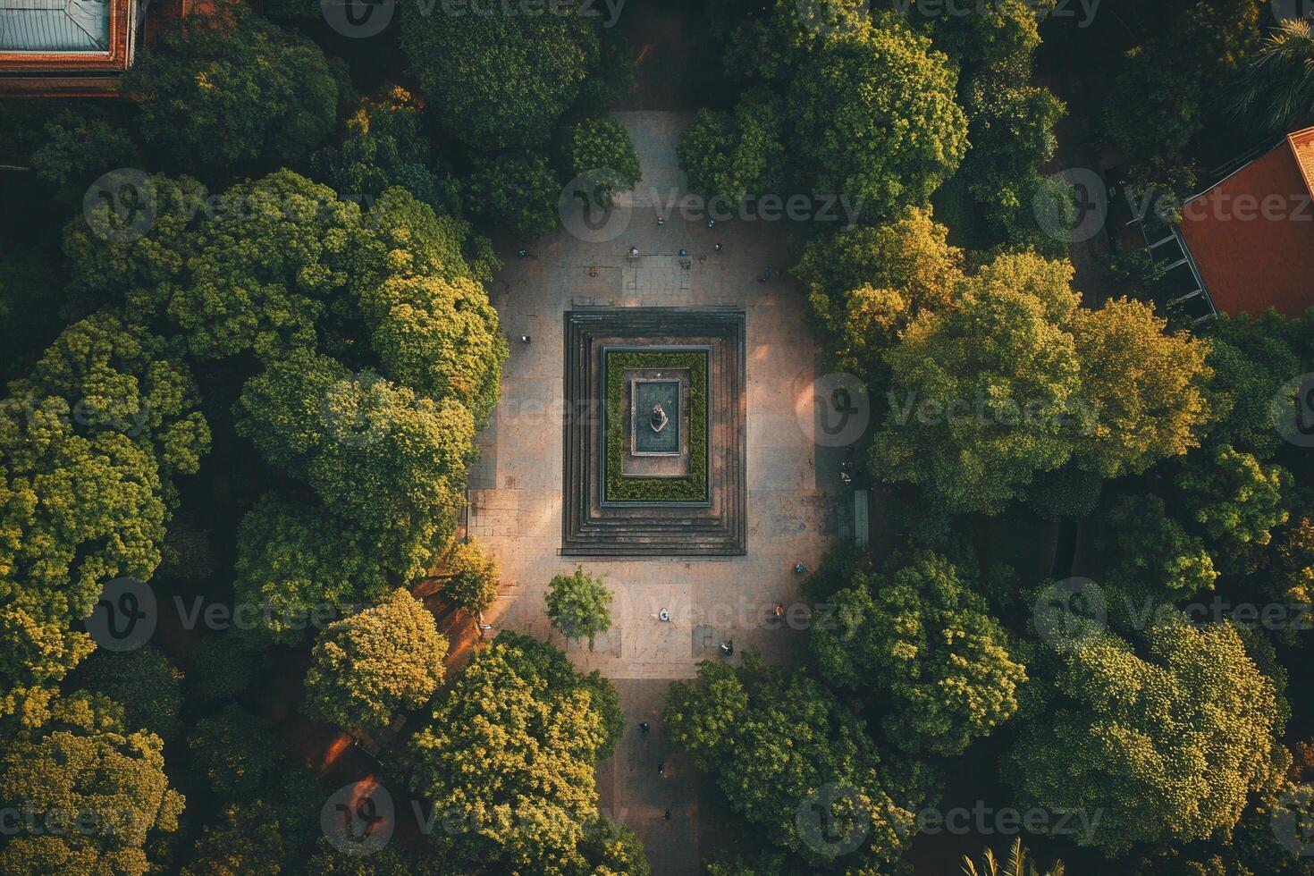 Aerial view of a square park with a central monument surrounded by lush green trees. photo