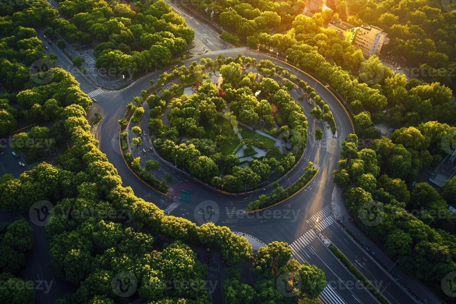 Aerial view of a circular road surrounded by lush greenery at sunset. photo