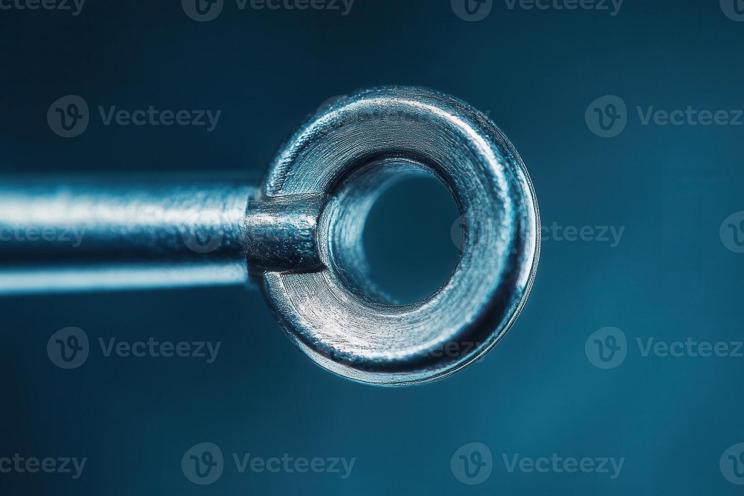 Close-up of a metallic ring on a rod, showcasing its texture and detail against a dark blue backdrop. photo