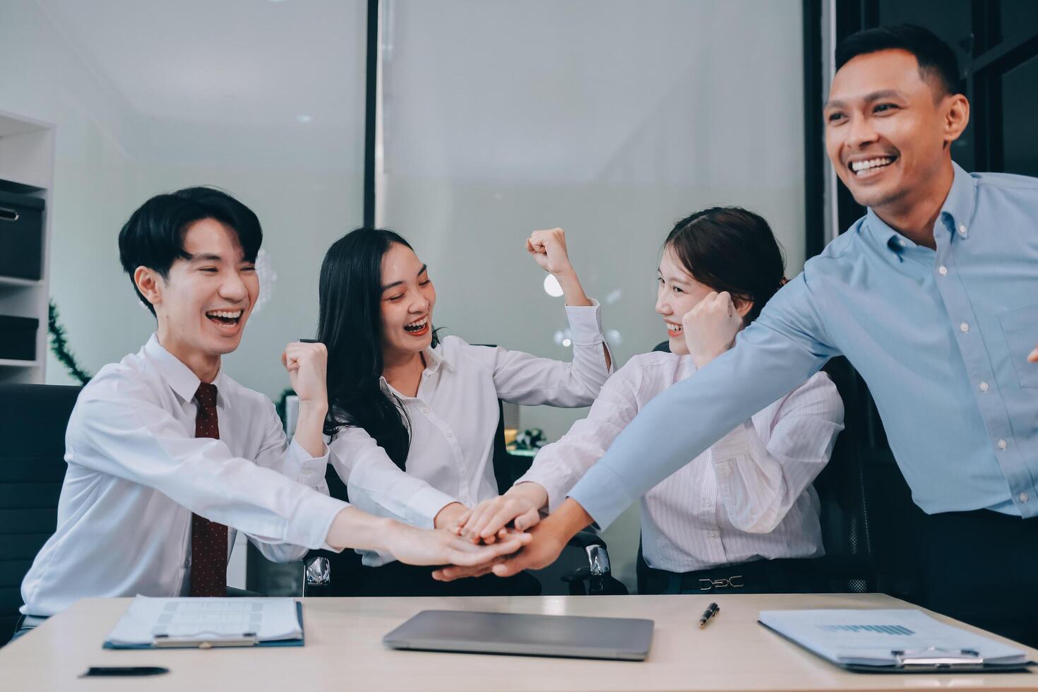 Group of business workers standing with hands together at the office photo