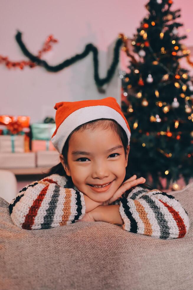 christmas, x-mas, winter, happiness concept - dreaming girl in santa helper hat photo
