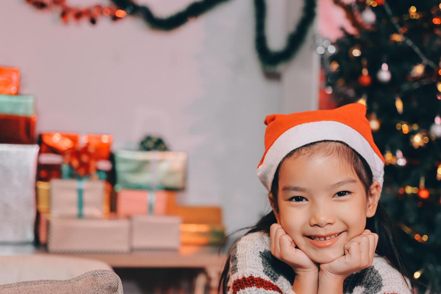 christmas, x-mas, winter, happiness concept - dreaming girl in santa helper hat photo