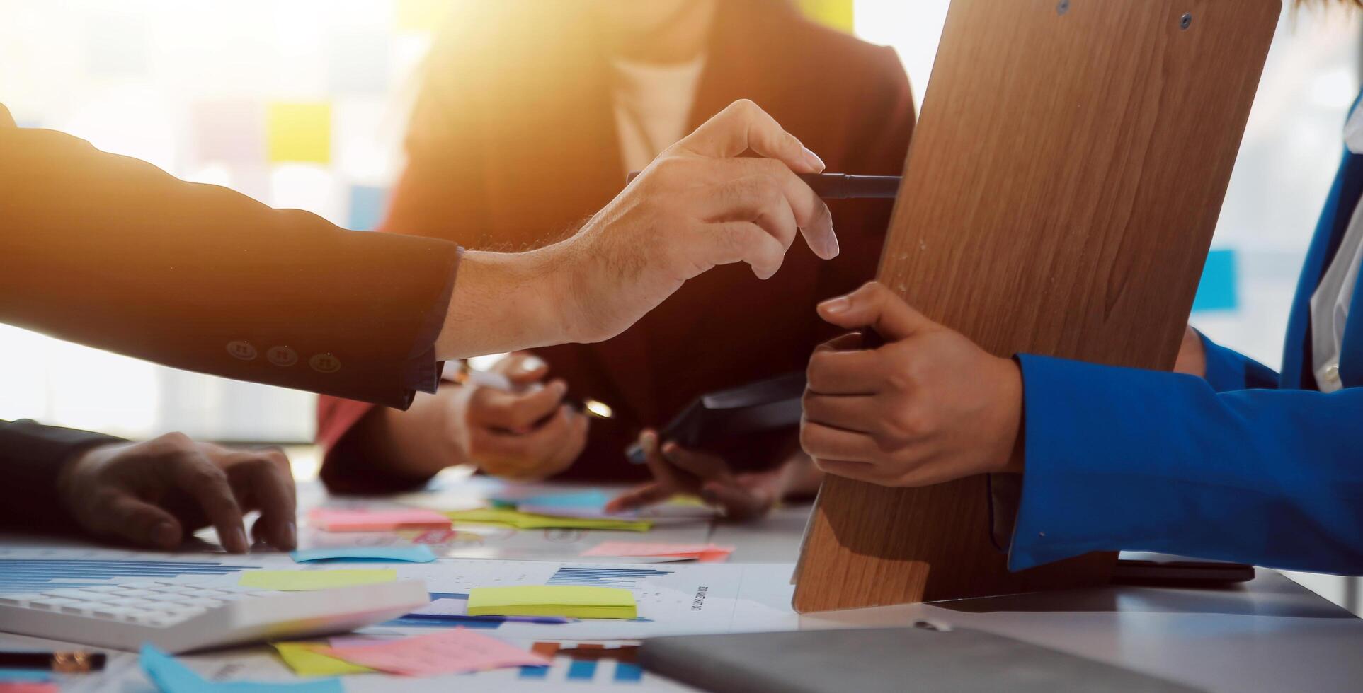 Meeting with business partners to discuss financial advisors to analyze market growth charts in business reports and plan investment strategies. photo