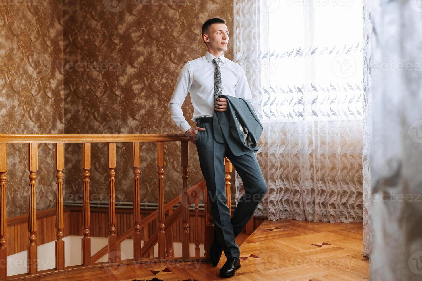 A man in a suit and tie stands on a staircase photo