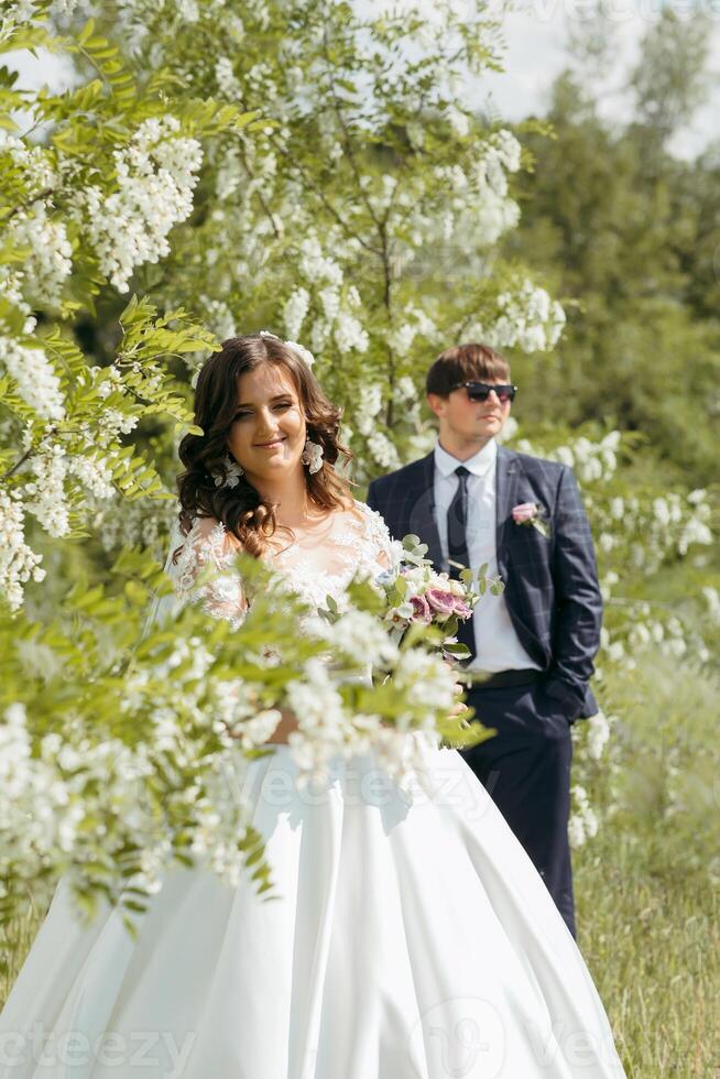 A bride and groom are standing in a field of flowers photo