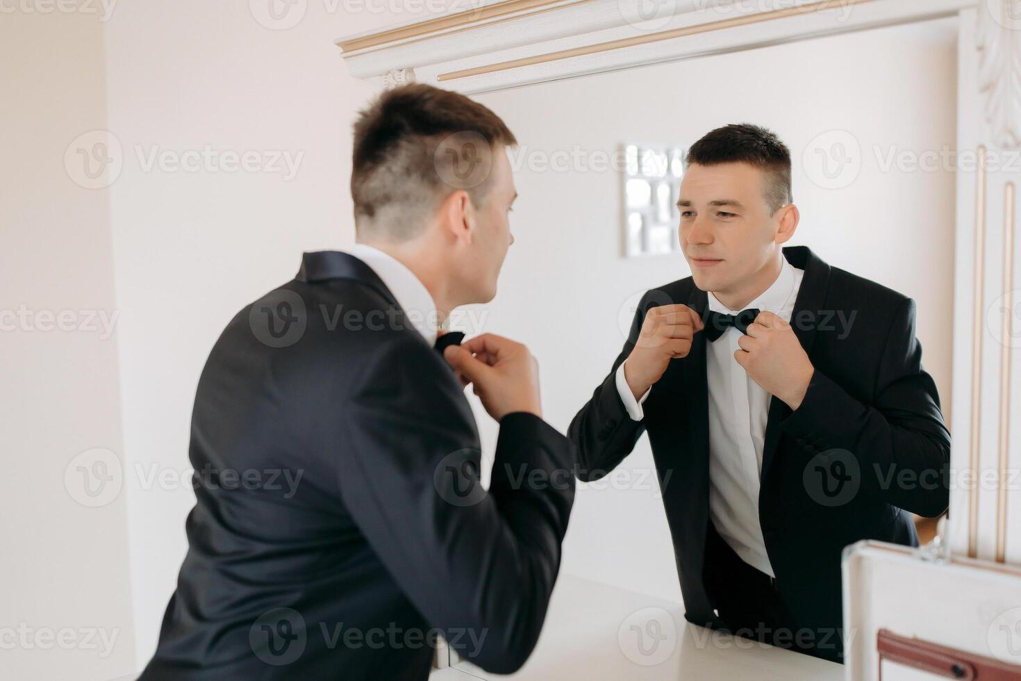 A man in a suit is getting ready to tie his tie photo