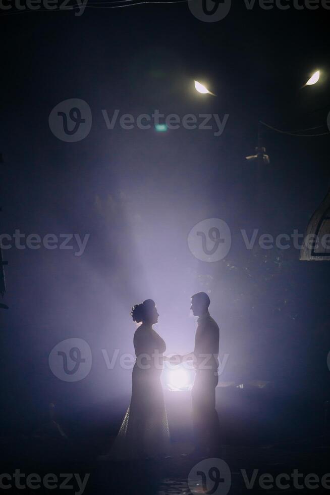 A couple is standing in the rain, holding hands photo