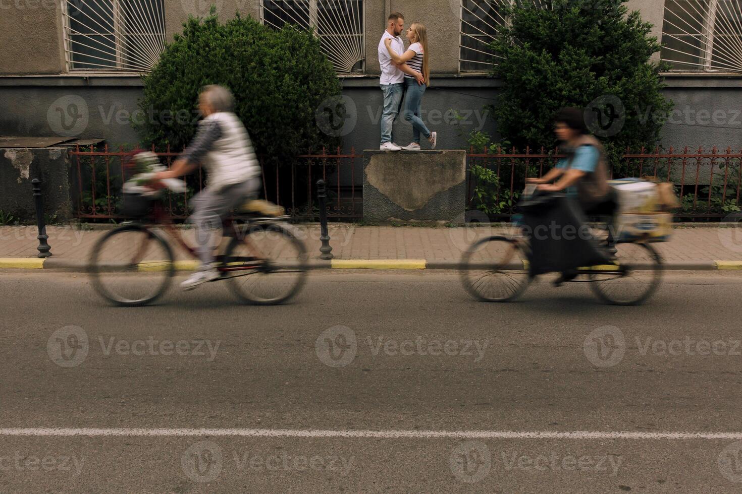 A couple is kissing on a bike in the street photo