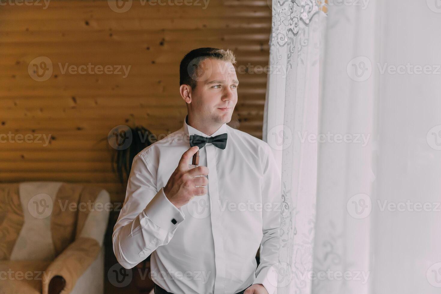 A man in a suit and tie is getting ready to go out photo