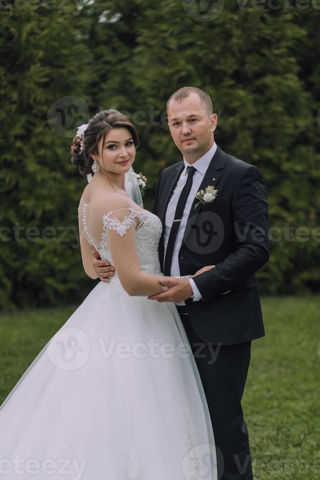 A bride and groom are posing for a picture in a field photo