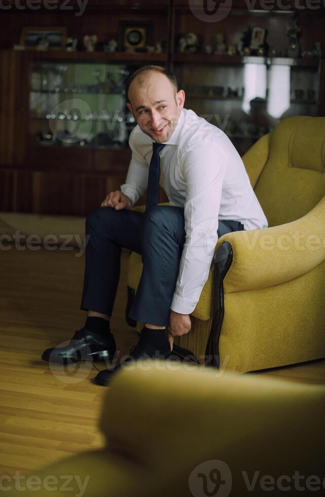 A man in a suit and tie sits in a yellow chair photo