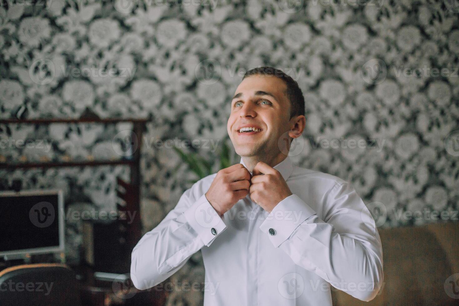 A man is getting ready to wear a white shirt photo