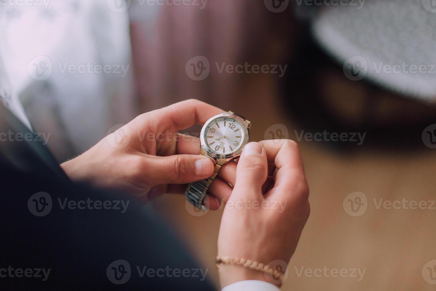 A person is holding a watch and looking at it photo