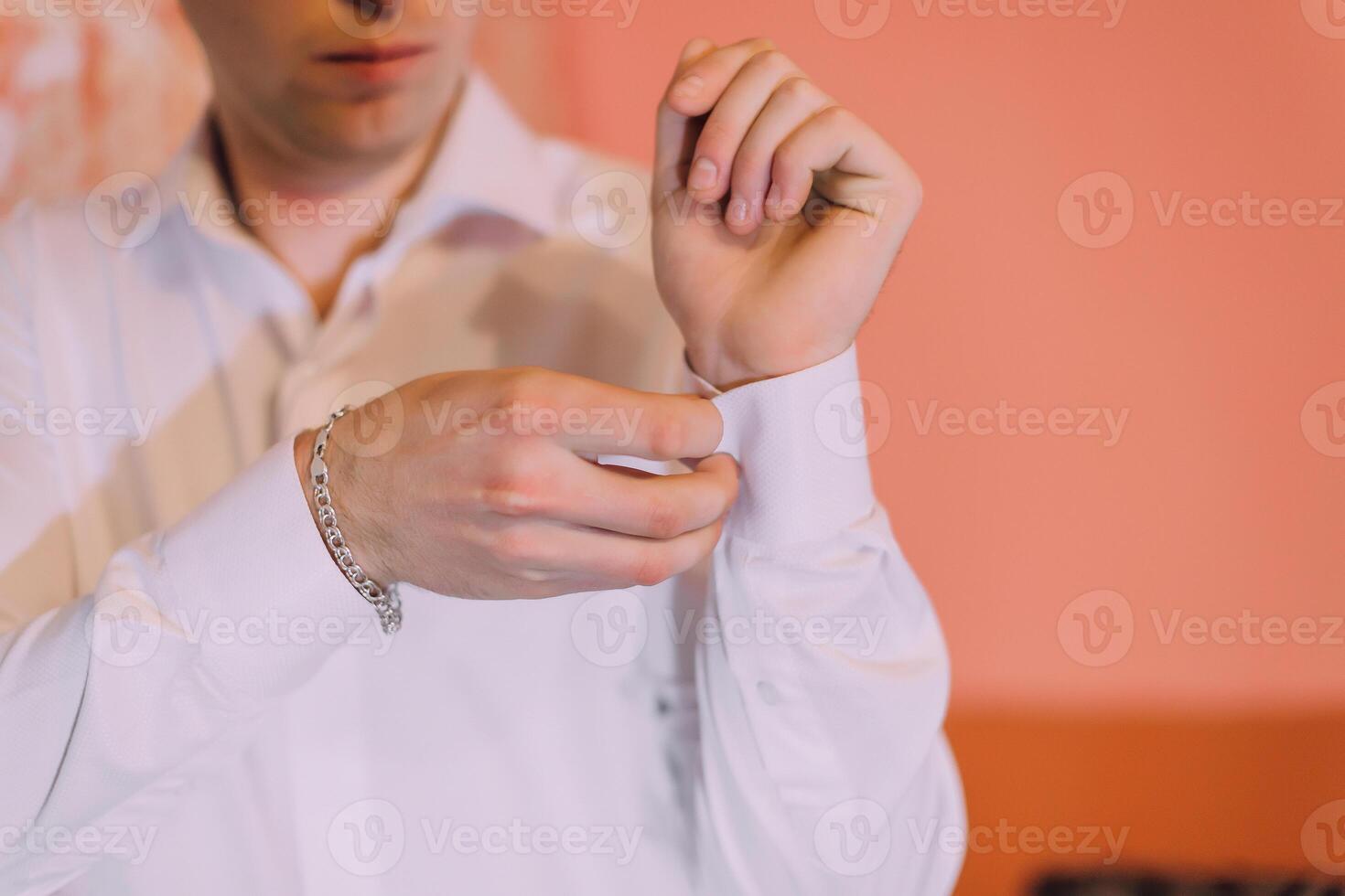 A man is getting dressed and adjusting his shirt photo