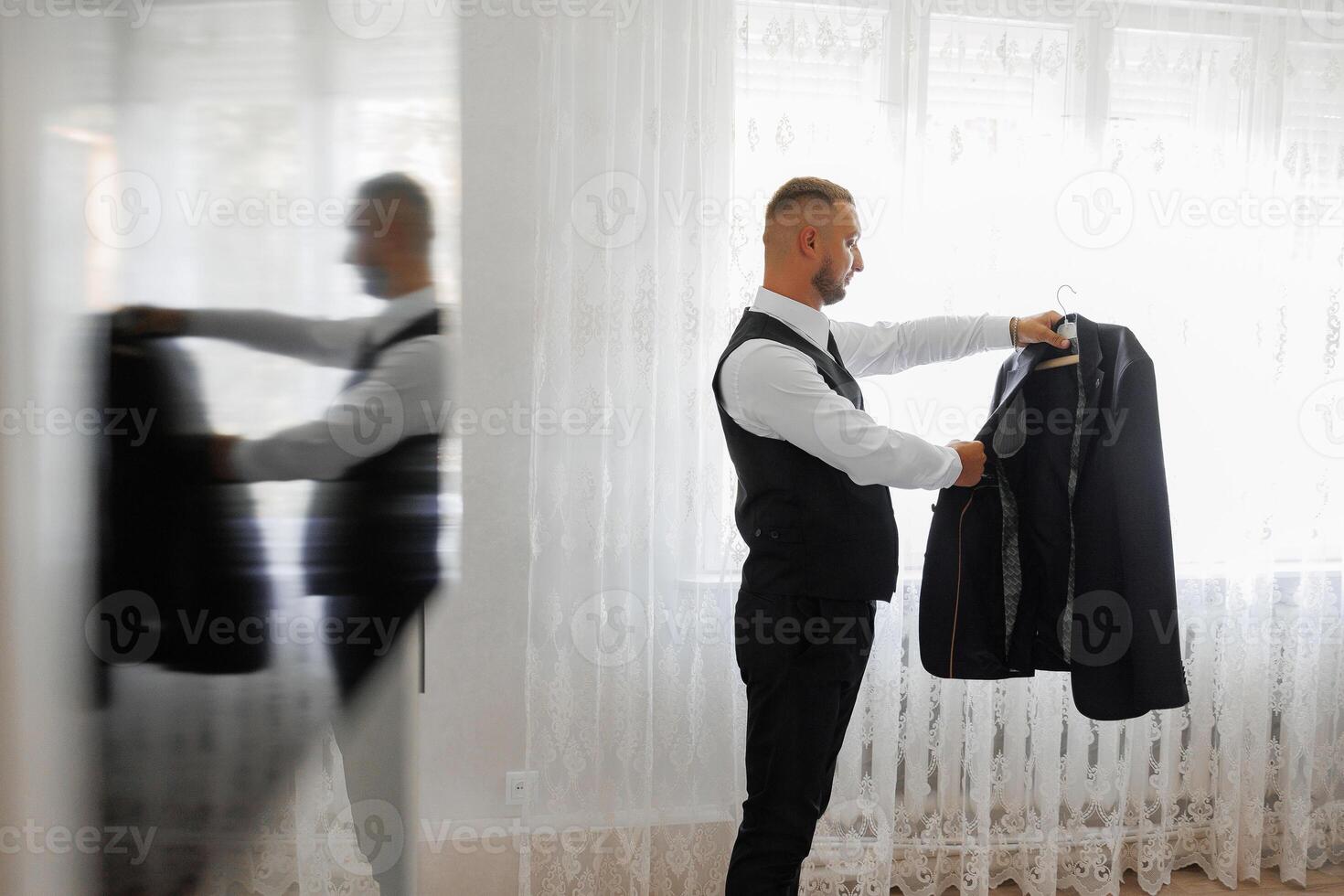 A man in a suit is hanging his jacket on a hanger photo
