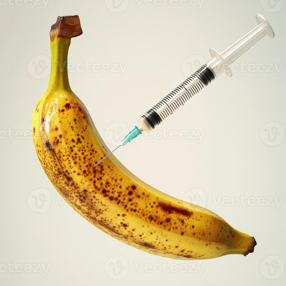 syringe injecting into a ripe banana. The syringe is held carefully, with the needle visibly piercing the smooth surface photo