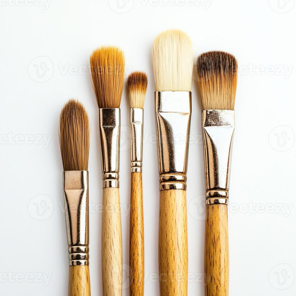 Five paintbrushes standing on white background photo