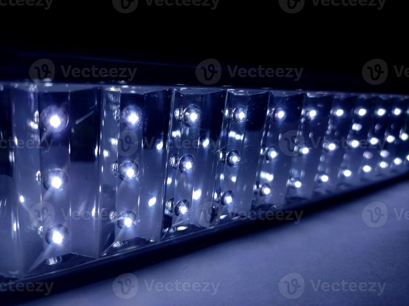 A close-up of a bright LED light bar with multiple LEDs in a rectangular pattern. The lights emit a strong white glow, showcasing their intensity, clarity, and intricate details. photo