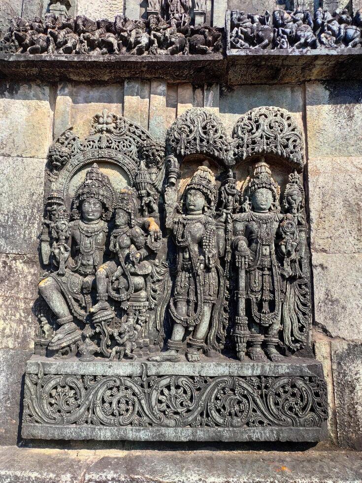Ornate wall panel reliefs depicting,from left, Vishnu with his consort Lakshmi, Paravati and Shiva. Ranganayaki, Andal, temple, Chennakesava temple complex, Belur, Karnataka, india West wall. photo