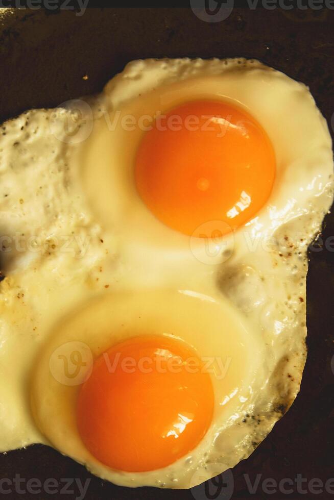 Two eggs are cooking in a frying pan photo