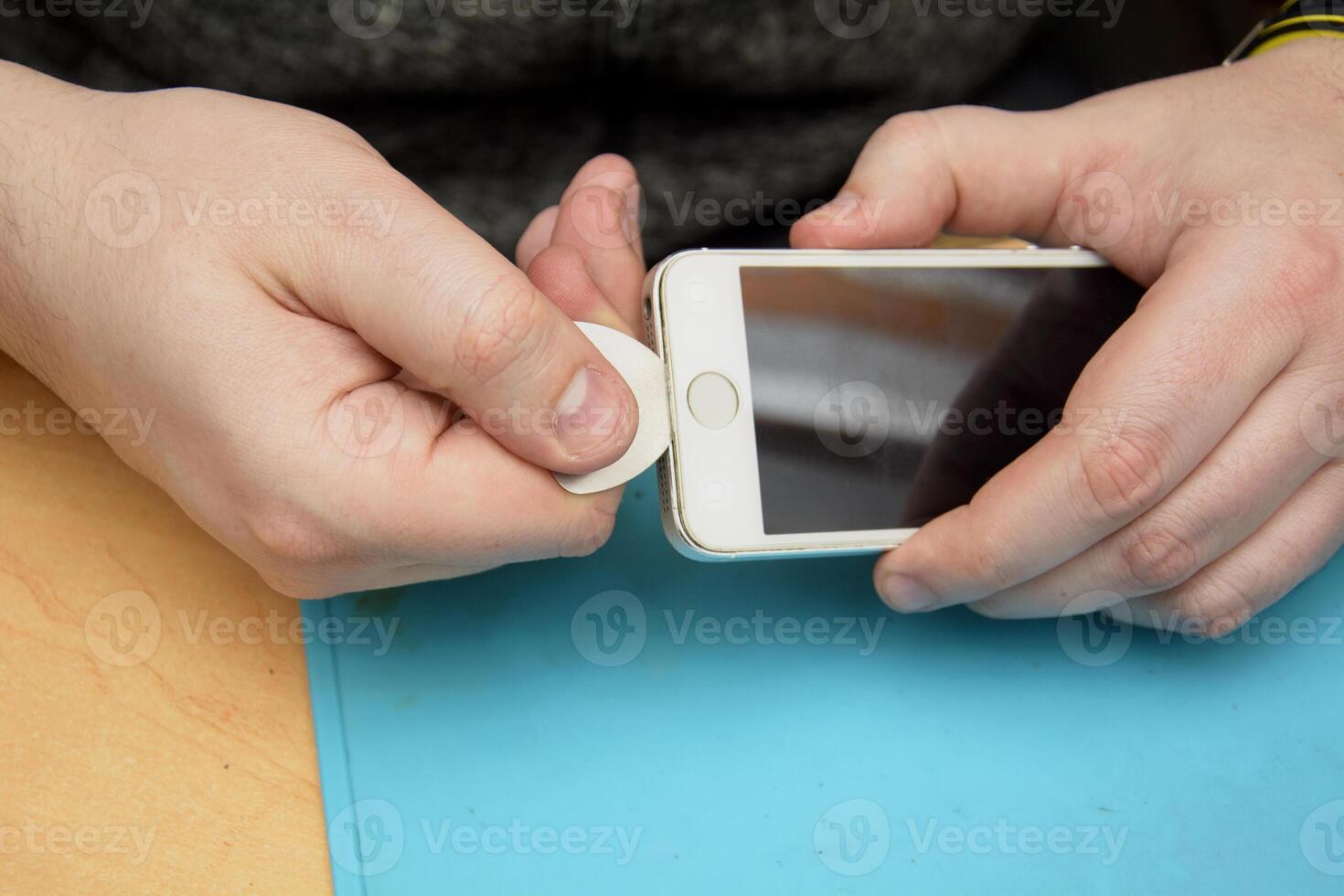 A person is holding a cell phone with a small button photo