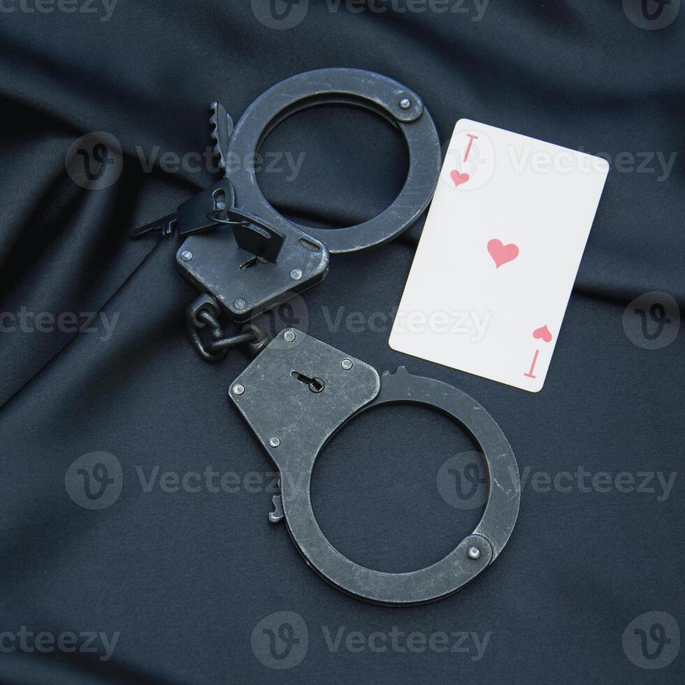 Handcuffs and playing cards on a black cloth photo