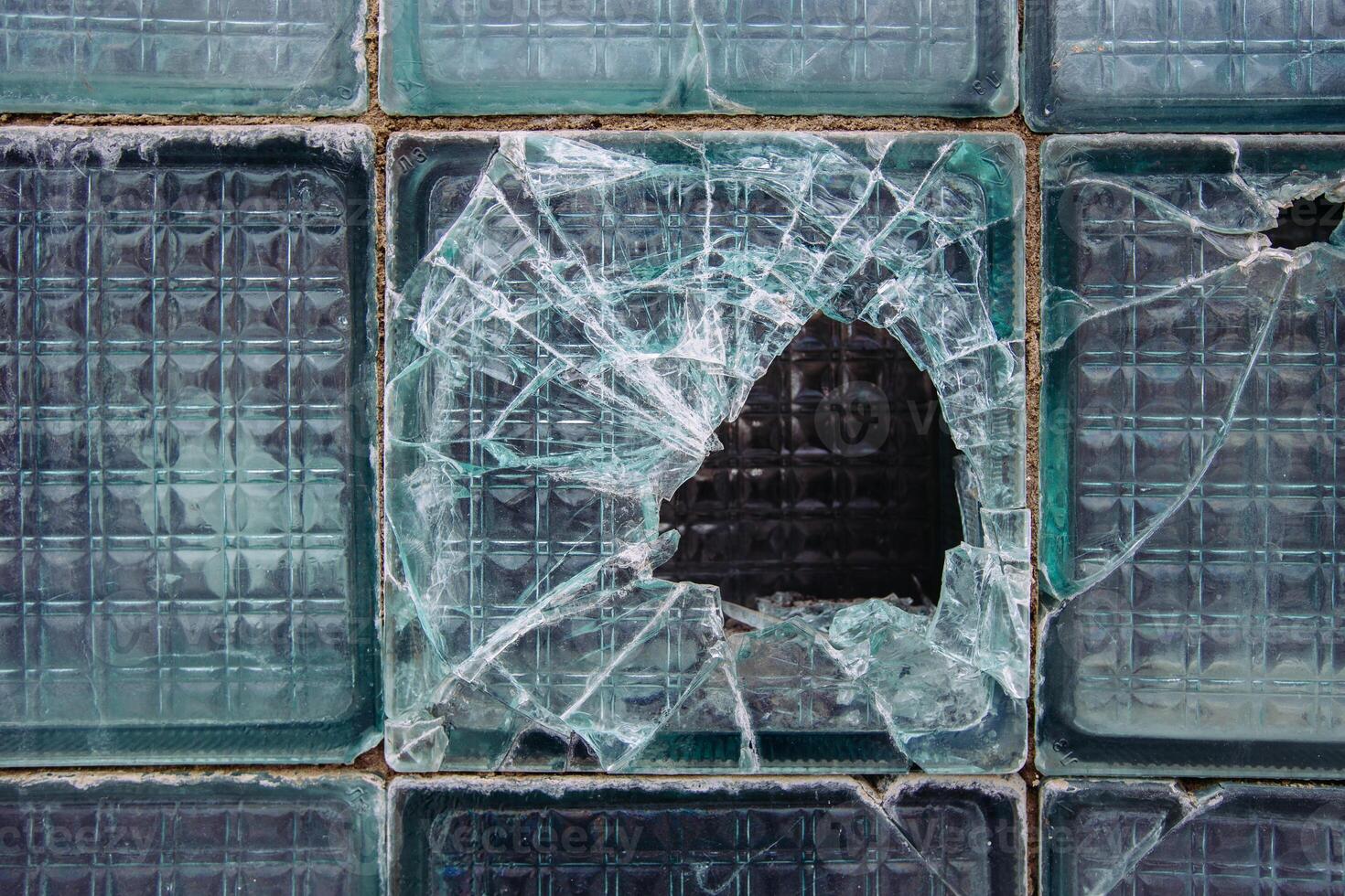 Old broken glass block window, close up view photo