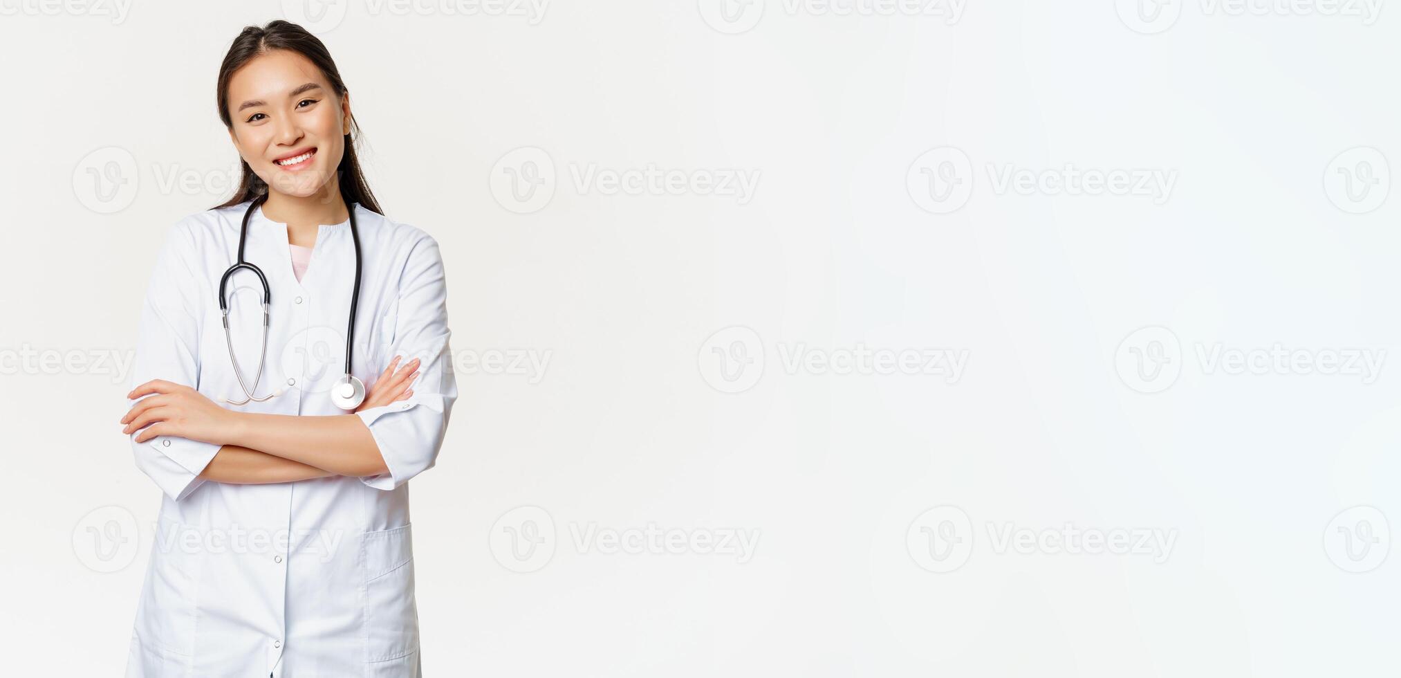 Asian female doctor, physician in medical uniform with stethoscope, cross arms on chest, smiling and looking like professional, white background photo