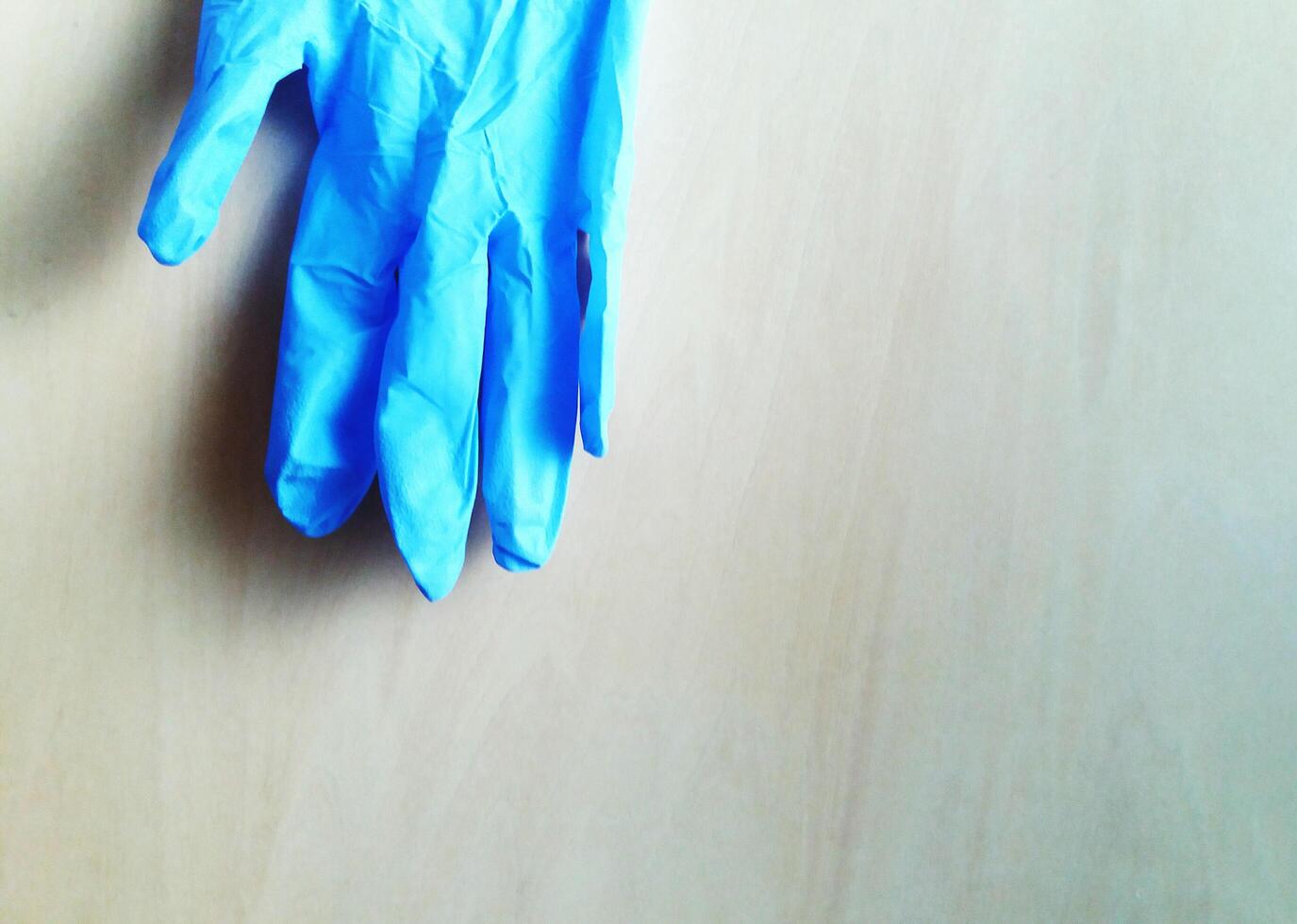 Blue Rubber gloves to wear when cleaning floors or bathrooms to protect against cleaning agents. Object hanging on wall with copy space. photo