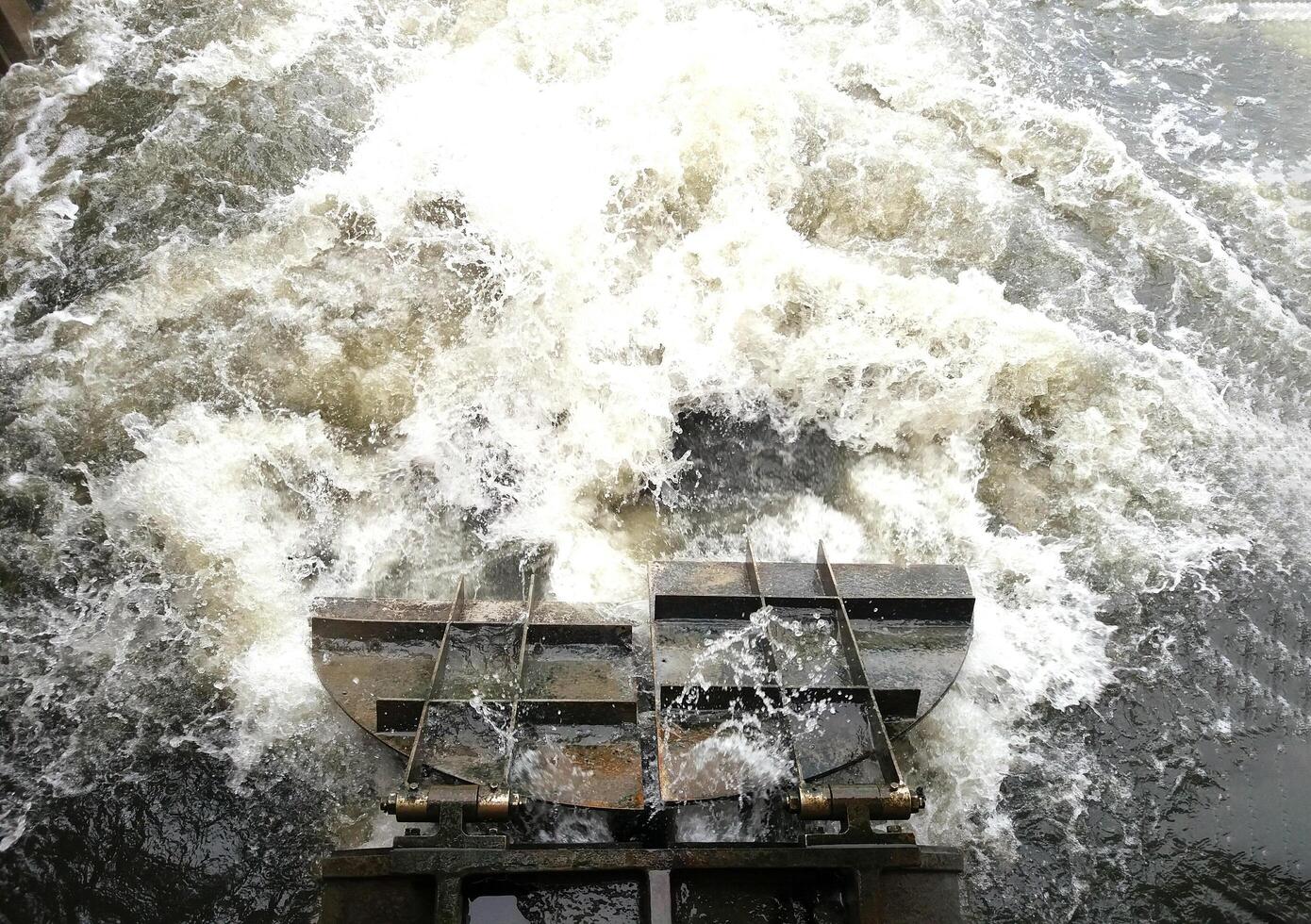Top view of a floodgate or dam where water is flowing very fast and strong. photo