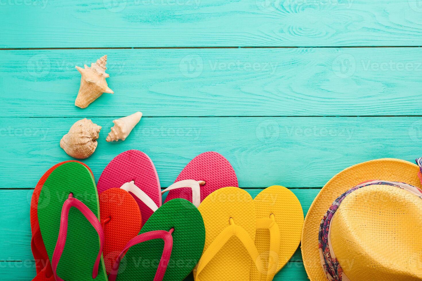 Colorful flip flops and hats on a blue wooden table photo