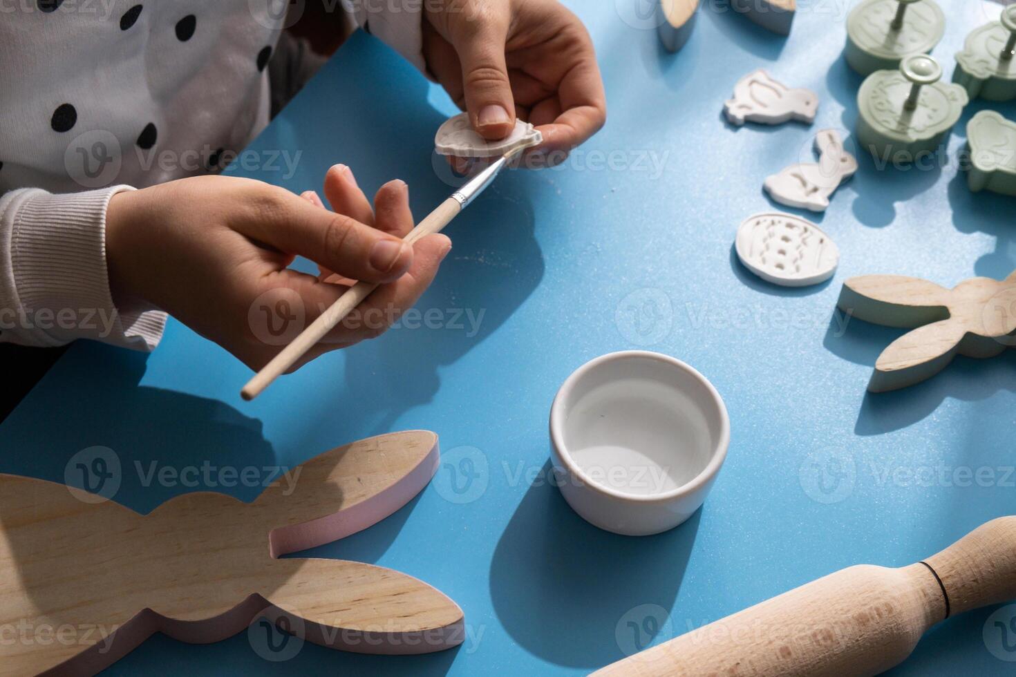 Master class of painting Creator is using white air dry clay for making decor to EASTER holiday. Creating hobby recreation activity that involves fingers. DIY crafting Modern art photo