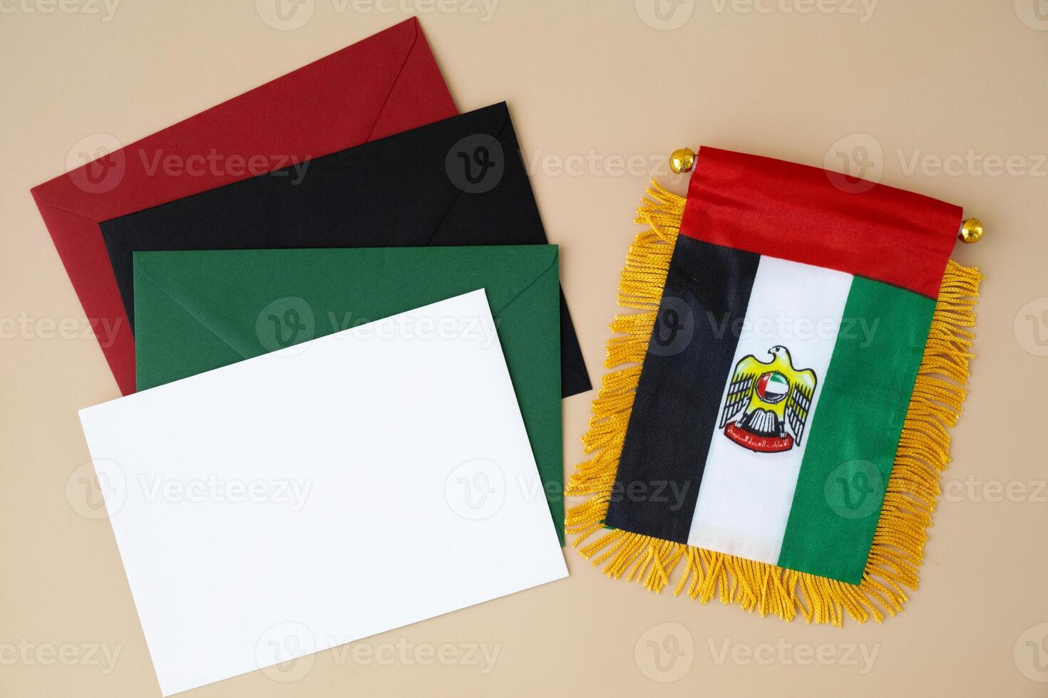 Small flag of UAE on beige background with colorful envelopes. Copy space. Mock up advertisement template. Tourism travel voucher with United Arab Emirates national symbol. Visit Dubai concept photo