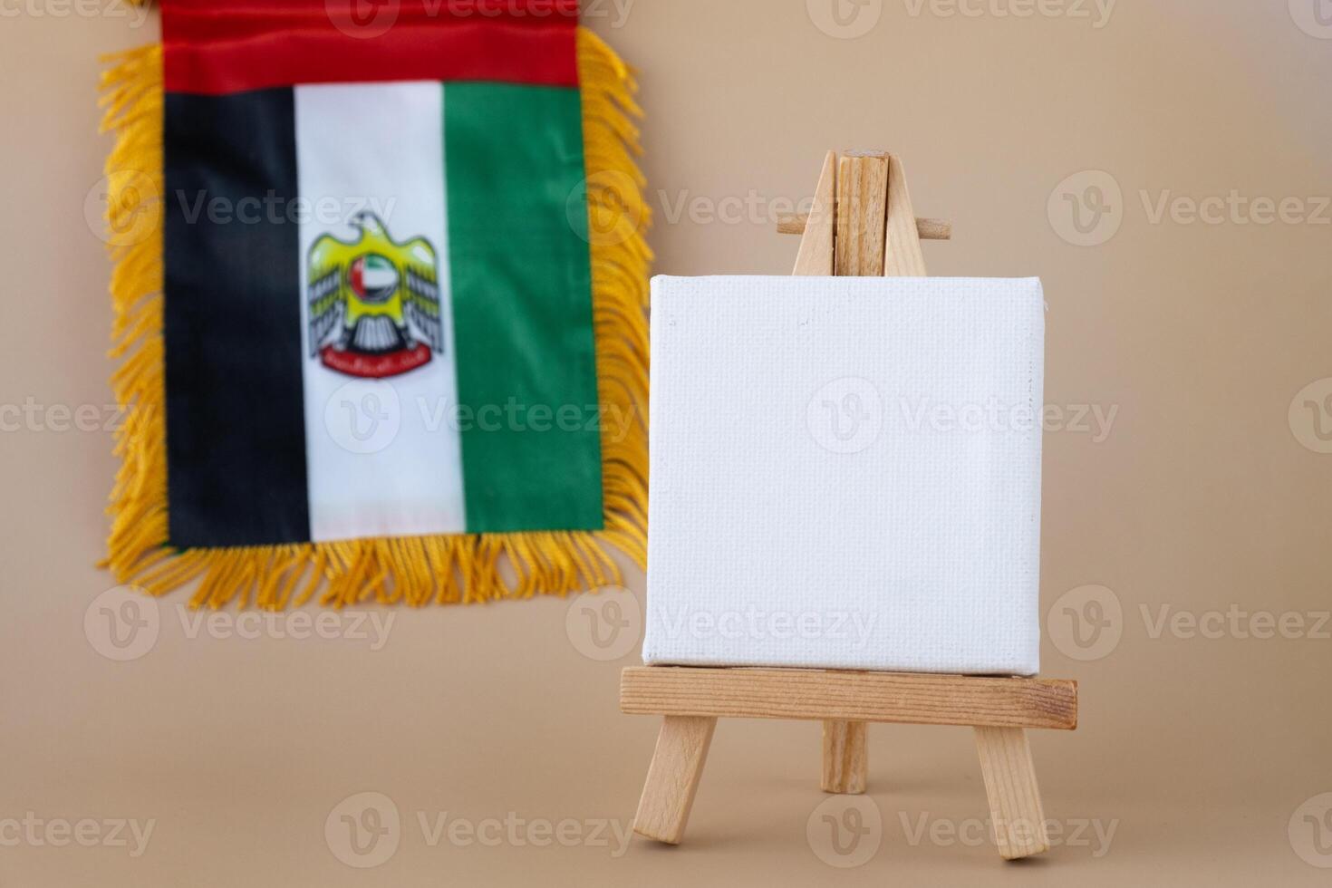 Empty white paper board template National symbol of UAE. United Arab Emirates small flag with Peregrine falcon on neutral beige background. Copy space for your text. Concept of National day Independence photo