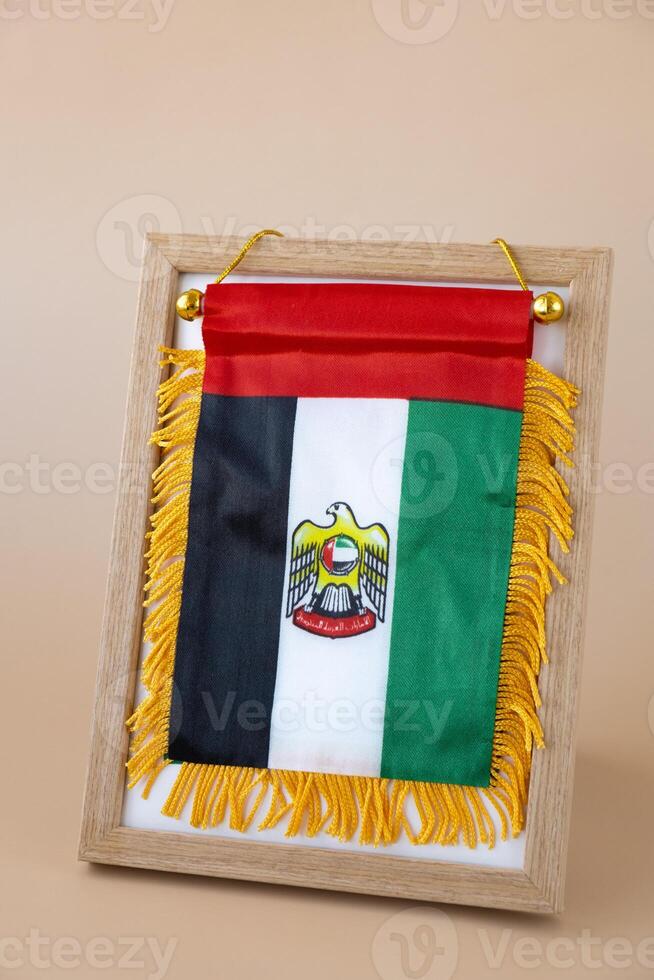 Small flag of UAE in beige background. Copy space. Mock up advertisement template. Tourism travel voucher with United Arab Emirates national symbol. Visit Dubai concept photo