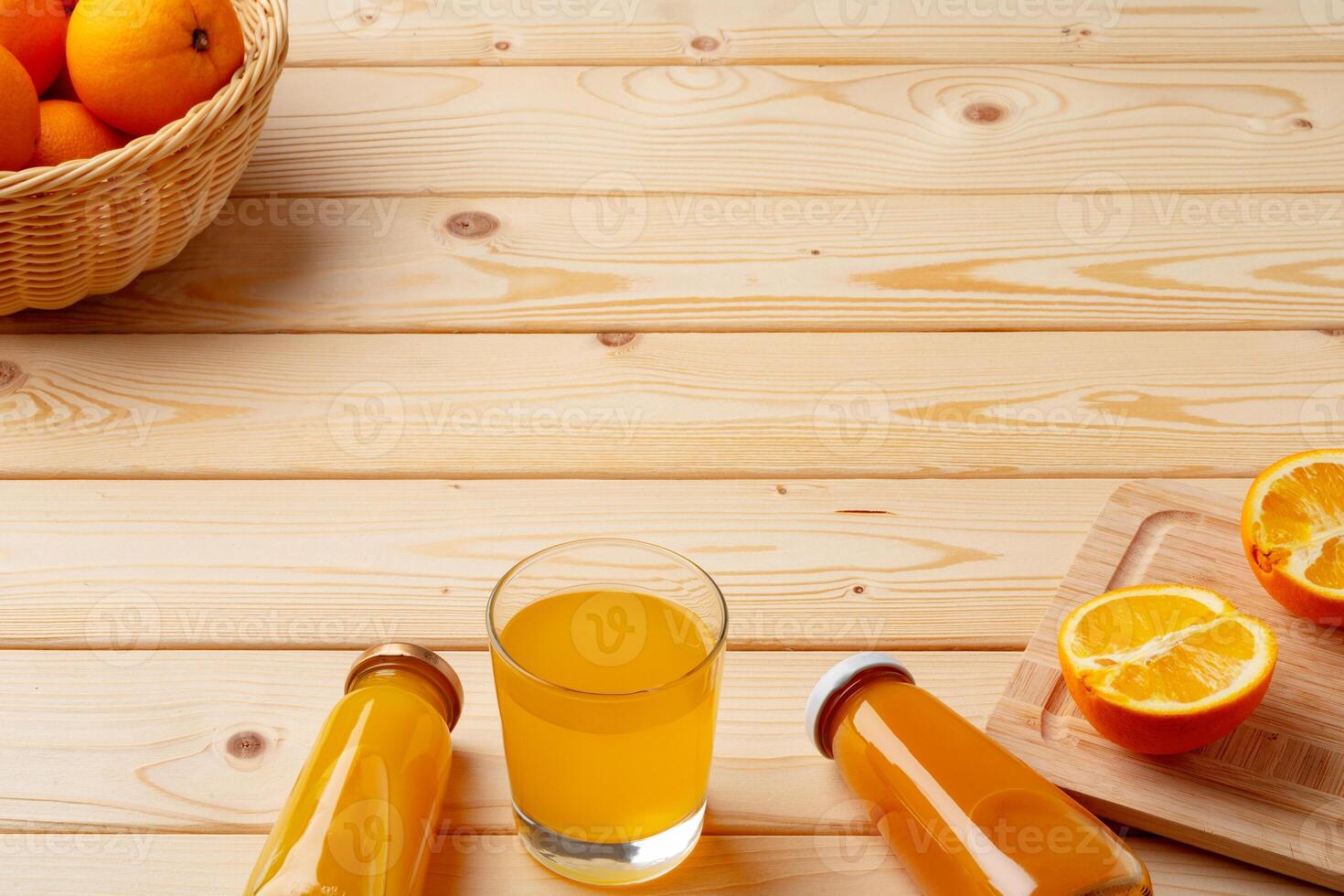 Glass of fresh orange juice with fresh fruits on wooden table photo