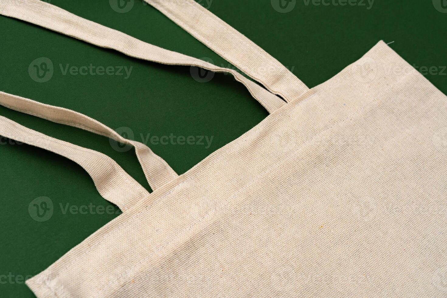 Textile shopping bag on green background flat lay photo