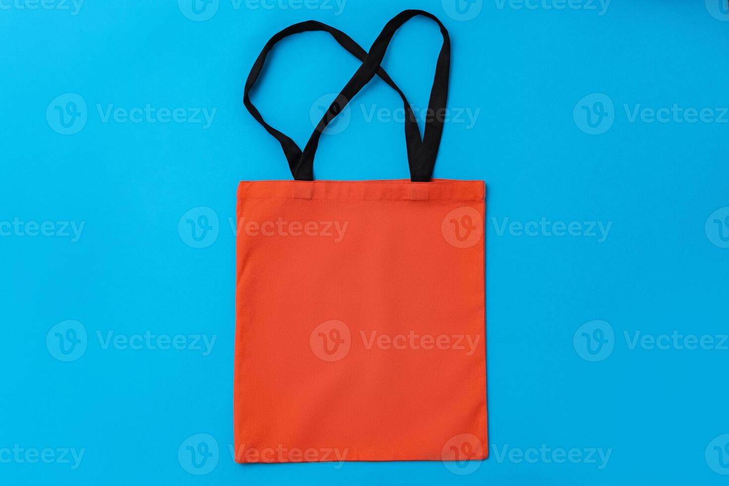 Textile shopping bag on blue paper background flat lay photo