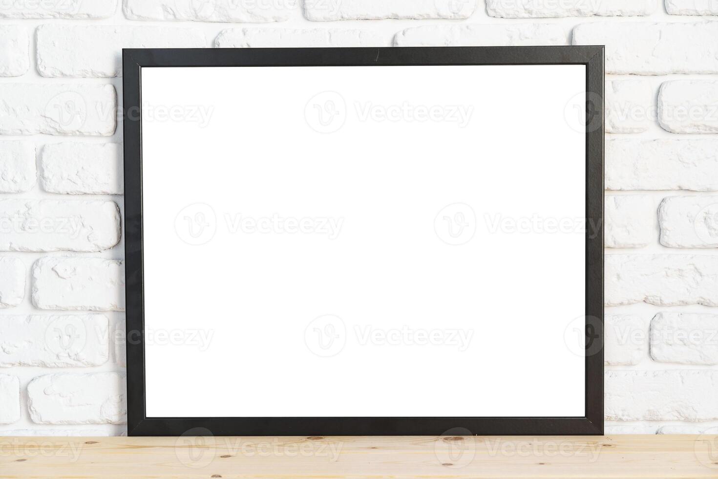 Photo frames on floor over white brick wall
