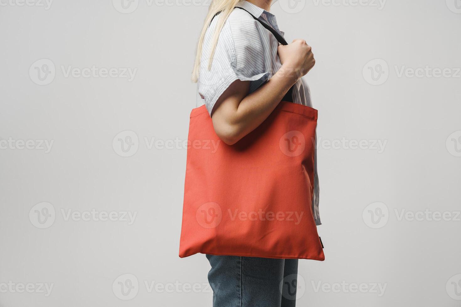 Cropped image of woman holding color shopping bag in studio photo