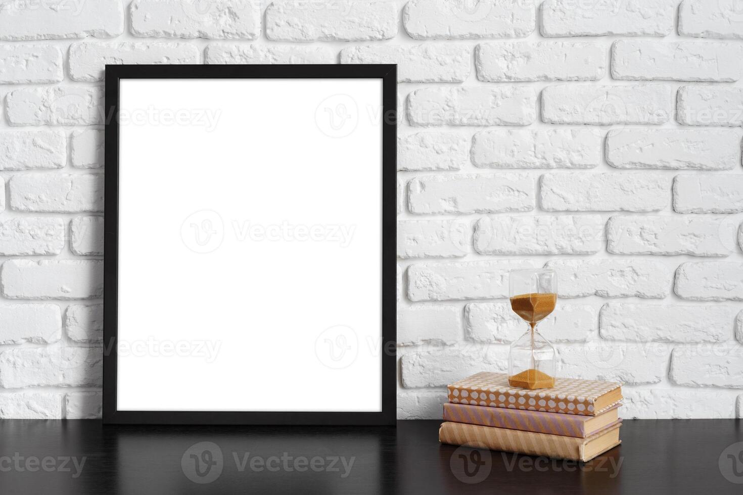Books with picture frame on wooden table photo
