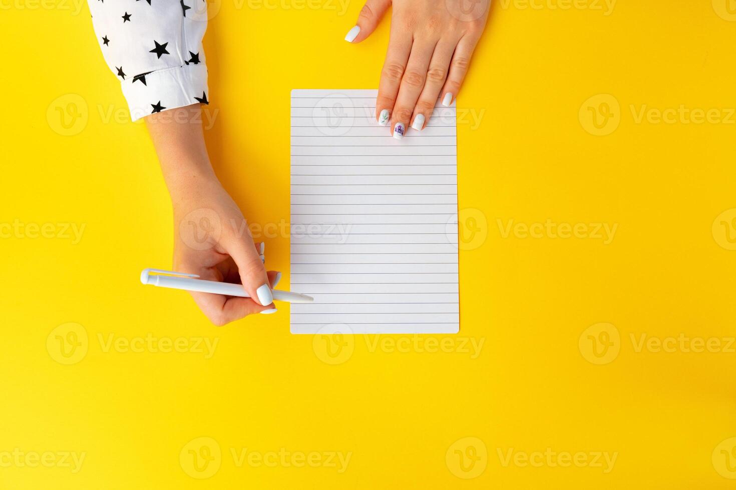 To do list. Top view of female hands writing in notebook photo